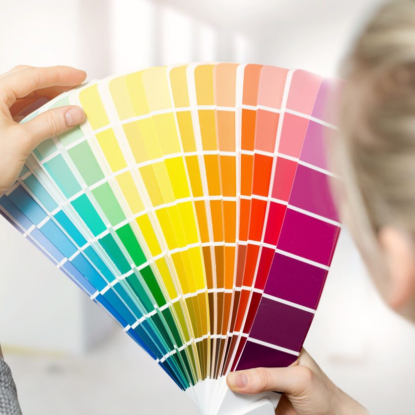 woman selecting home interior paint color from swatch catalog